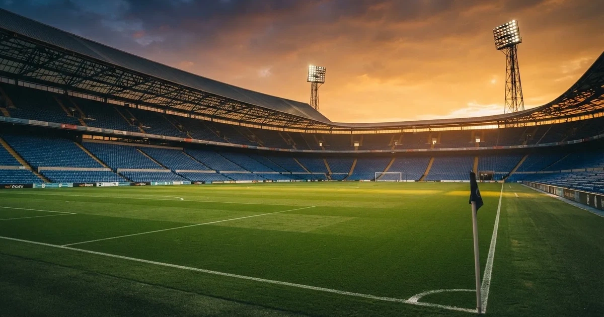 Un estadio de fútbol vacío con torres de iluminación al atardecer