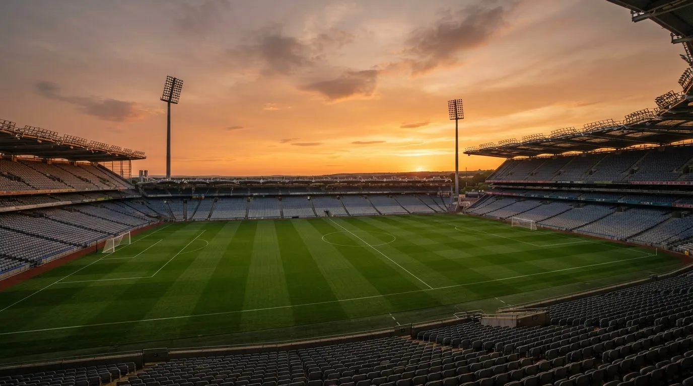 Un estadio de fútbol vacío con torres de iluminación al atardecer