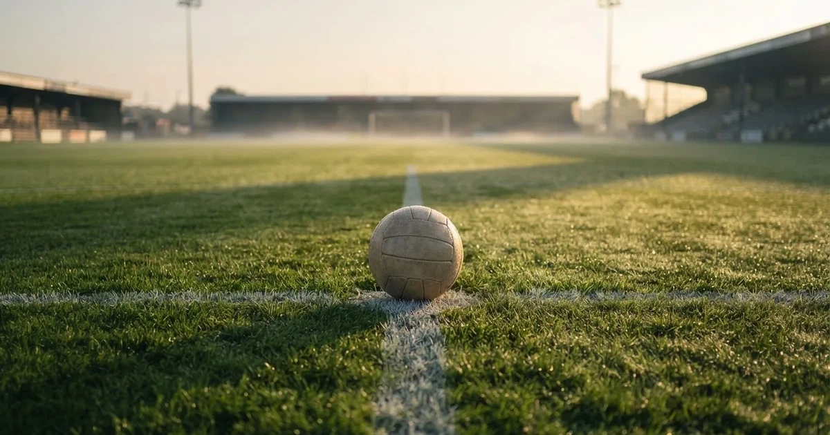 Un balón en el punto central de un campo de césped a la luz de la mañana